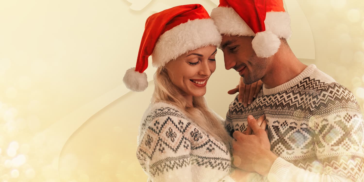 Young couple in love with santa hats dancing together